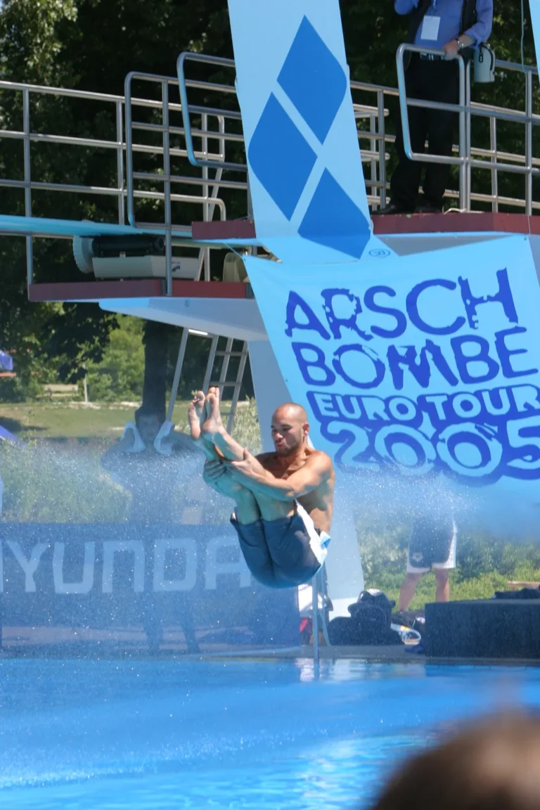 Ein Springer dicht über der Wasseroberfläche vor dem Arschbombe-Eurotour-2005-Banner.