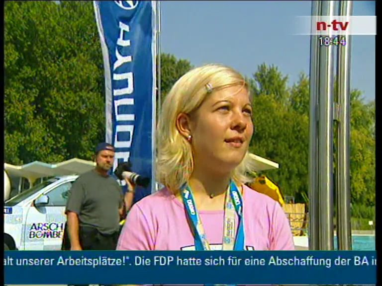 Filmstandbild aus n-tv: Wettkampfturm und Publikum an der Arschbombe-Weltmeisterschaft.