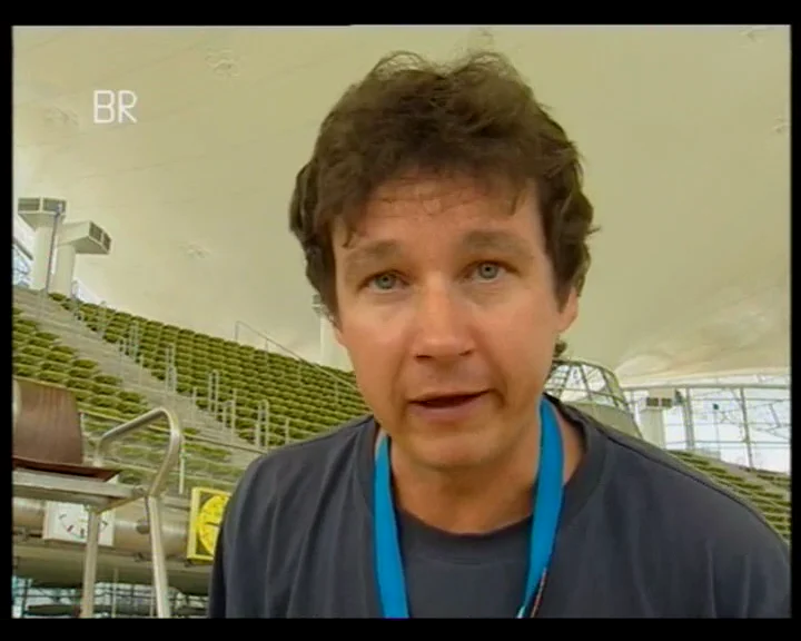 Filmstandbild: BR-Reporter in der Münchner Olympia-Schwimmhalle.