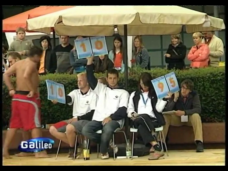 Die Jury hält am Beckenrand Wertungstafeln hoch, im Galileo-Archivbeitrag.