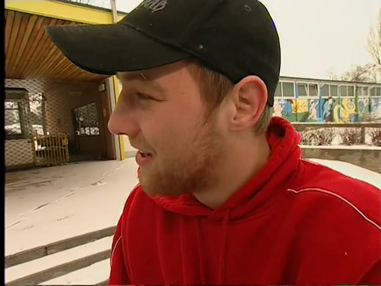 Christian “Elvis” Guth in a red tracksuit top, interviewed outside the Kreuzsteinbad.