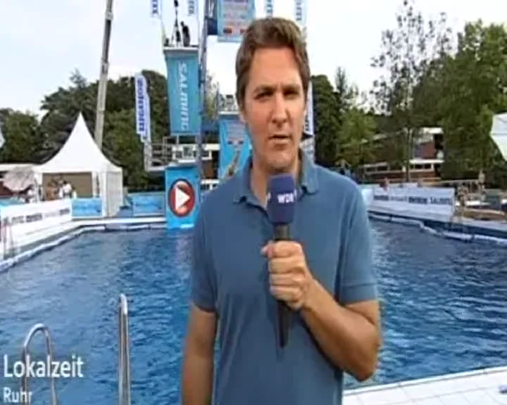 Filmstandbild: WDR-Reporter am Wettkampfbecken.